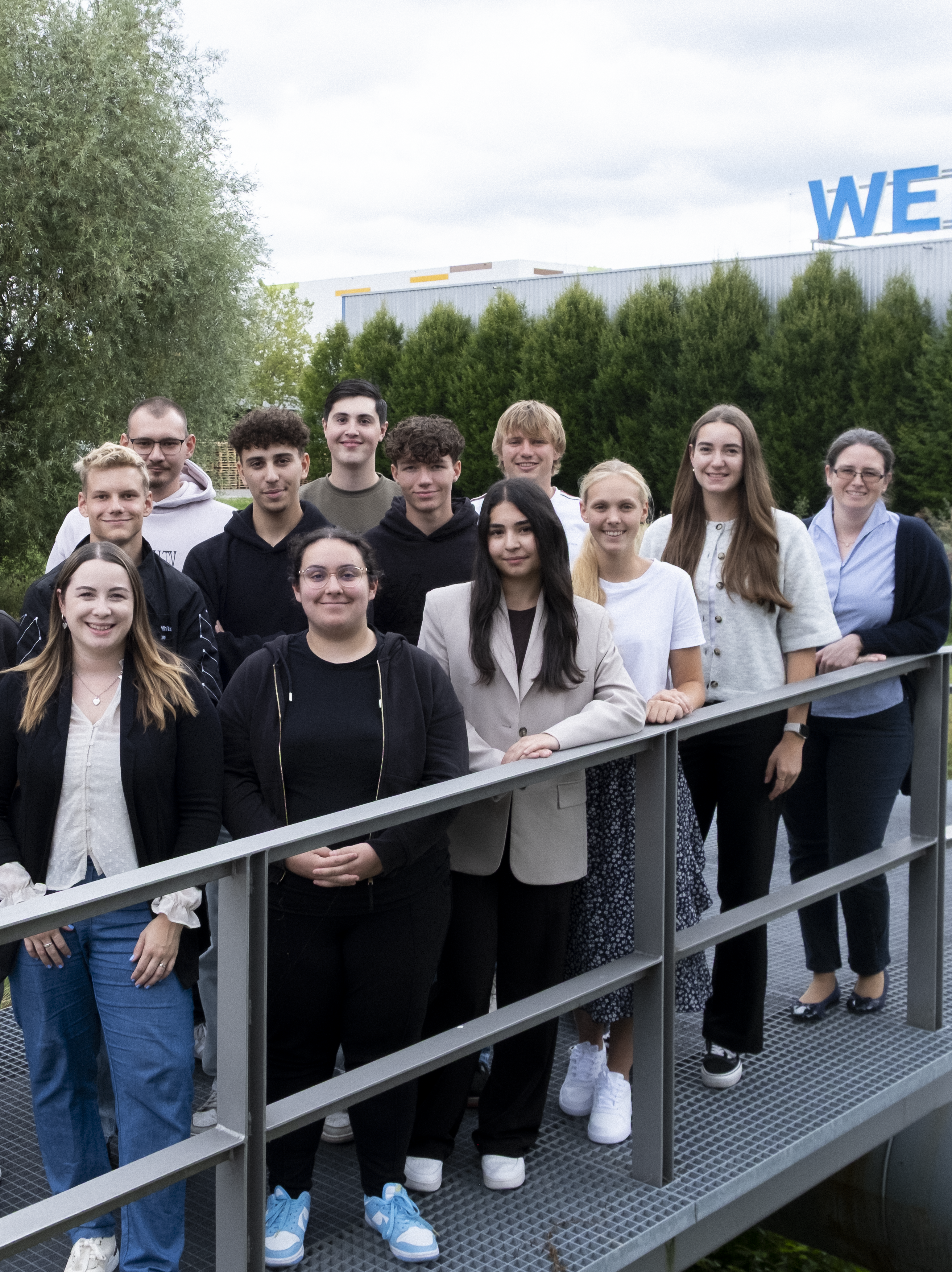 Uzin Utz Auszubildende stehen gemeinsam auf Steg im Grünen und präsentieren die vielfältigen Karrierechancen