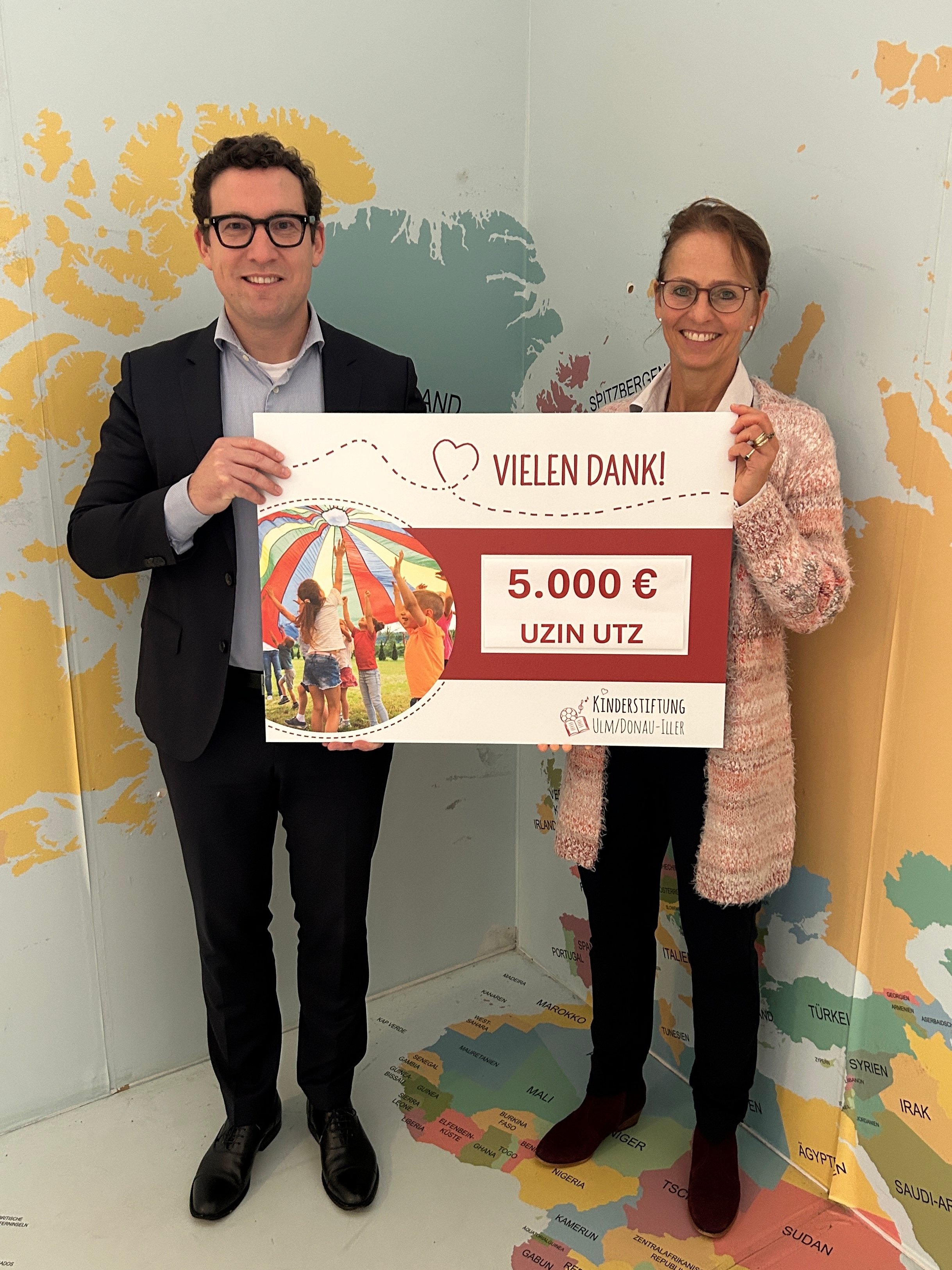 Zwei Personen mit gro&szlig;em Spendenscheck &uuml;ber 5.000 Euro, Uzin Utz engagiert sich sichtbar f&uuml;r soziale Projekte